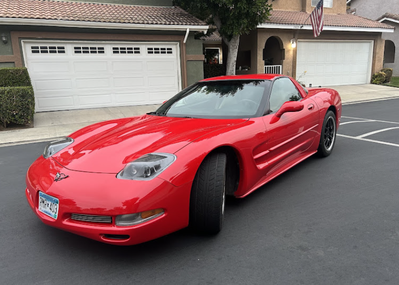 Freshly detailed red Chevrolet Corvette with mirror-gloss paint in a Bay Area driveway
